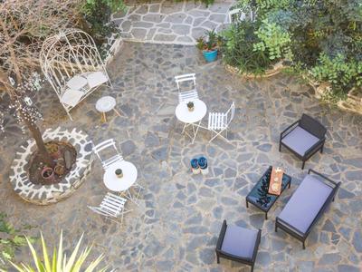 Vista aerea di un'area esterna lastricata con sedie, tavoli e piante.