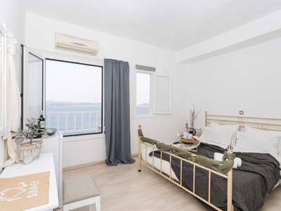 Camera d'hotel moderna con letto matrimoniale, vista mare e scrivania.