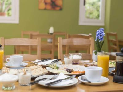Mesa de desayuno con café, jugo, croissants y otras delicias en un restaurante.