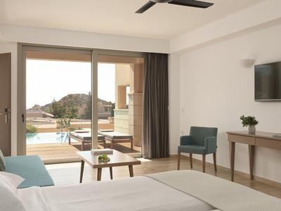 Camera d'hotel luminosa con terrazza e vista sulle montagne.