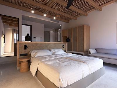 Camera d'hotel moderna con letto matrimoniale, divano grigio e arredamento minimalista.