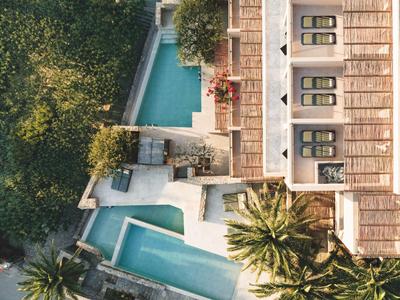Vista aerea di un hotel con due piscine circondate da palme e vegetazione