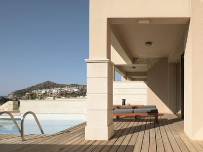 Piscina moderna dell'hotel con lettini su terrazza in legno sotto cielo sereno