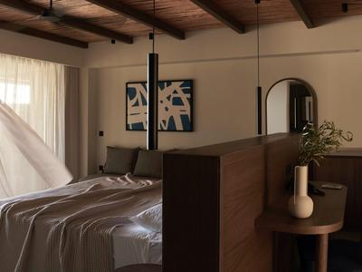 Camera rustica con soffitto a travi in legno, letto accogliente e luce calda.