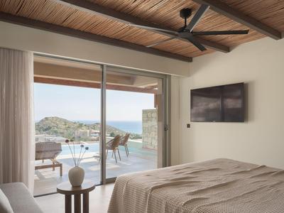 Camera da letto con soffitto in legno, letto grande e vista su terrazza con piscina e paesaggio panoramico.