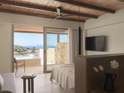 Camera d'hotel con letto matrimoniale, balcone e vista mare alla luce del giorno.