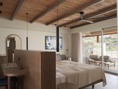 Modern eingerichtetes Hotelzimmer mit Doppelbett, Holzdecke und Terrasse mit Aussicht.