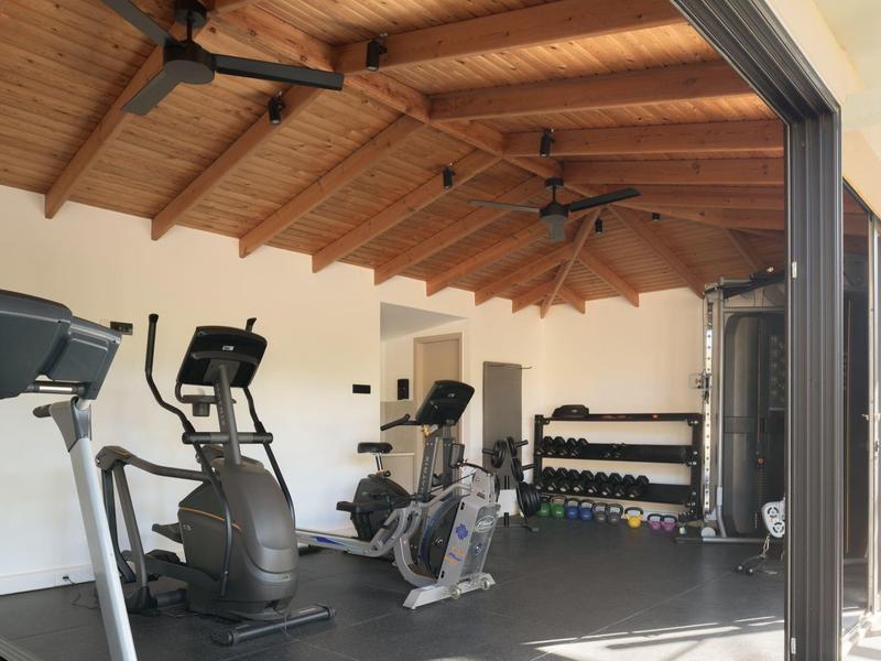 Palestra con attrezzature moderne e soffitto in legno.