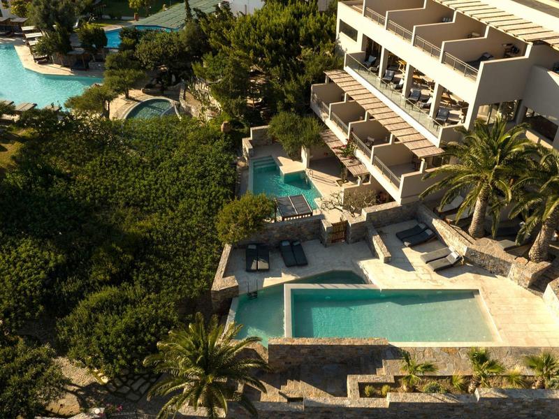 Veduta aerea di un complesso alberghiero con più piscine circondate da palme.