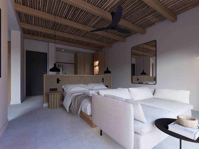 Camera d'hotel moderna con letto matrimoniale, divano bianco e arredo minimalista.