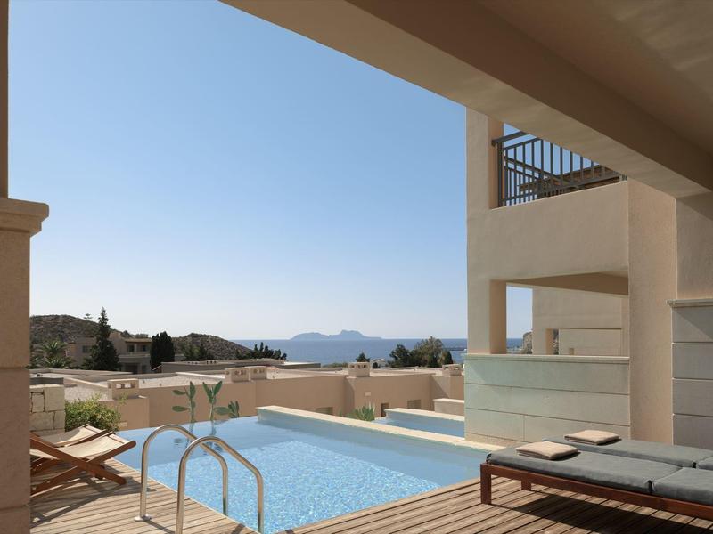 Piscina all'aperto tranquilla su terrazza con lettini e vista sulle montagne.