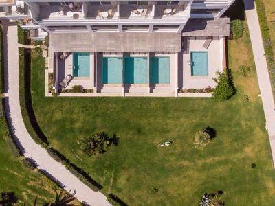 Widok z lotu ptaka hotelu z kilkoma basenami i dużym terenem zielonym.