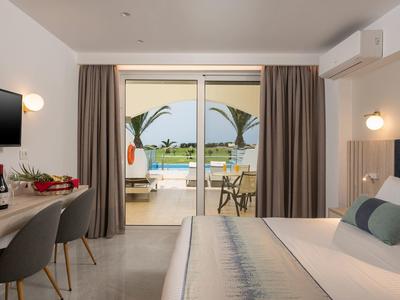 Modernes Hotelzimmer mit Doppelbett, Schreibtisch, TV, Balkon und Blick auf das Meer.
