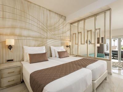 Nowoczesny pokój hotelowy z dwoma pojedynczymi łóżkami i przesuwnymi drzwiami na balkon.