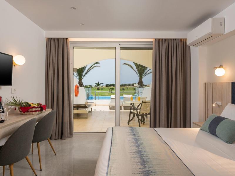 Modernes Hotelzimmer mit Doppelbett, Schreibtisch, TV, Balkon und Blick auf das Meer.