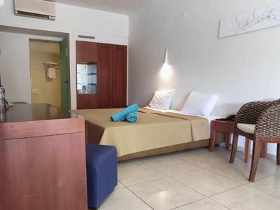 Ein modernes Hotelzimmer mit Doppelbett, Schreibtisch, Stühlen und Klimaanlage.