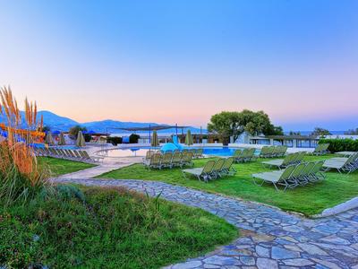 Luce serale nell'area piscina di un resort con lettini e vista sulle montagne.