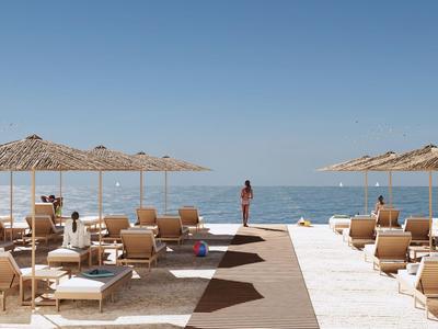 Spiaggia con sdraio e ombrelloni, persona rilassata che guarda il mare calmo.