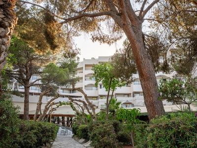Moderner Hotelbau umgeben von Bäumen und gepflegter Gartenanlage.