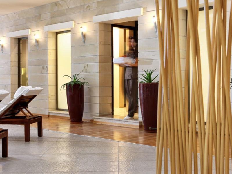 Moderní hotelová bazénová část s lehátky a velkými květináči