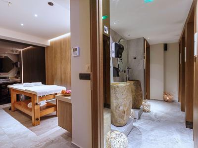 Modern wellness area with massage table and stylish decor in warm tones.