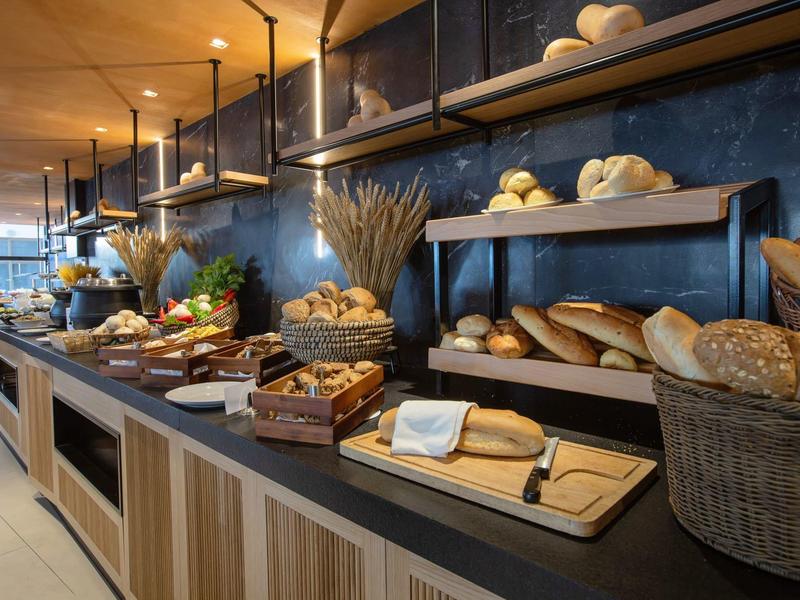 Buffet with a variety of fresh bread and pastries in a modern breakfast room