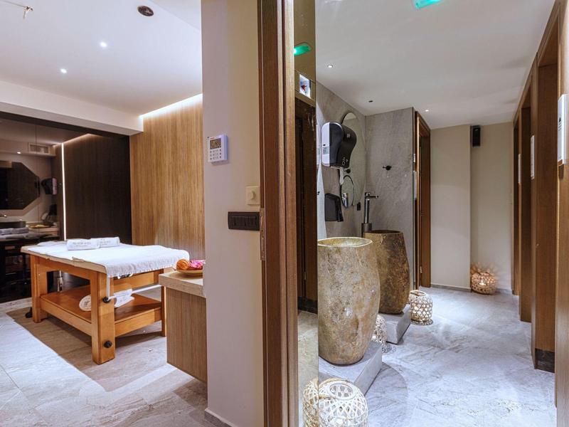 Modern wellness area with massage table and stylish decor in warm tones.