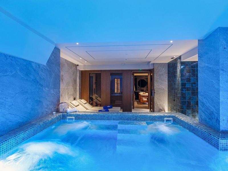 Indoor pool with whirlpool and sauna area in a relaxing atmosphere.