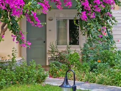 Ingang van een huis met bloemen boven het deurkozijn en een kleine tuin