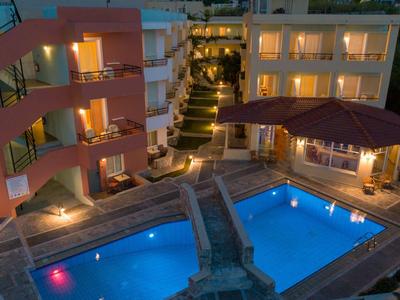 Beleuchteter Hotelpool mit Sonnenschirm und Sitzbereich in der Dämmerung