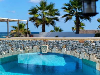 Zwembad met helder water voor palmbomen en blauwe lucht bij het hotel