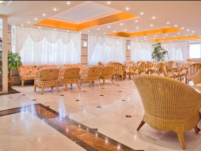 Heller, großer Hotel-Loungebereich mit rattanmöbeln und Marmorfußboden.