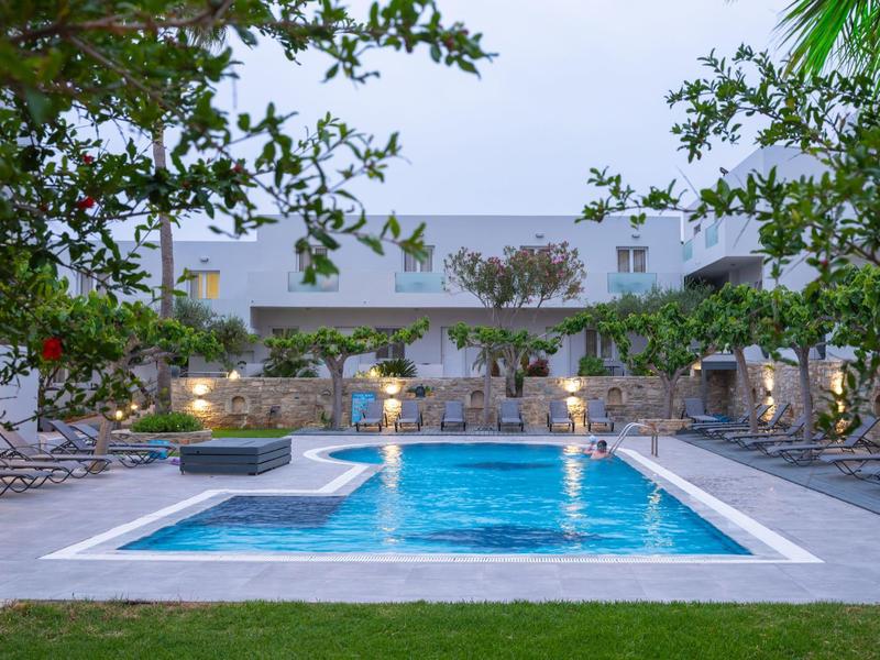 Modern pool with loungers and trees in a peaceful hotel garden.