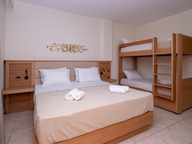 Cozy hotel room with double bed, bunk bed, nightstands, and towels.