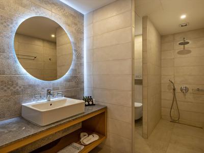 Moderne badkamer met verlichte spiegel, wastafel en inloopdouche.