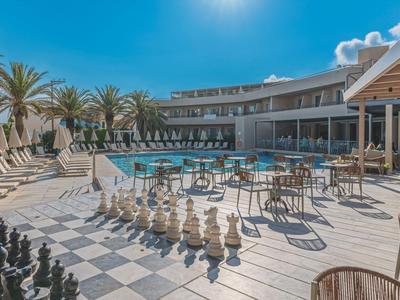 Modern hotel pool area with chessboard and sun terrace in bright sunshine.
