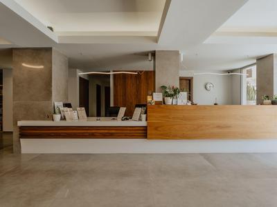 Moderní hotelová lobby s dřevěnou recepční přepážkou a minimalistickým zařízením.