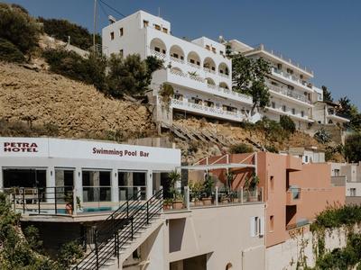 Mehrstöckiges Hotel auf einem Hügel mit mehreren Gebäuden und blühenden Pflanzen.