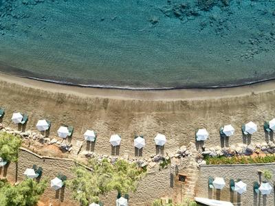 Aerial view of a beach with umbrellas and blue sea in the background.