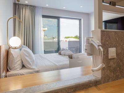 Nowoczesny pokój hotelowy z łóżkiem podwójnym, balkonem i suszarką do włosów w łazience.