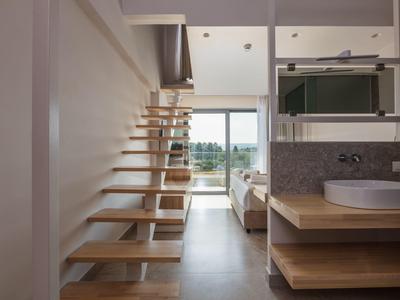 Nowoczesny pokój hotelowy z otwartymi schodami i widokiem na balkon oraz krajobraz.