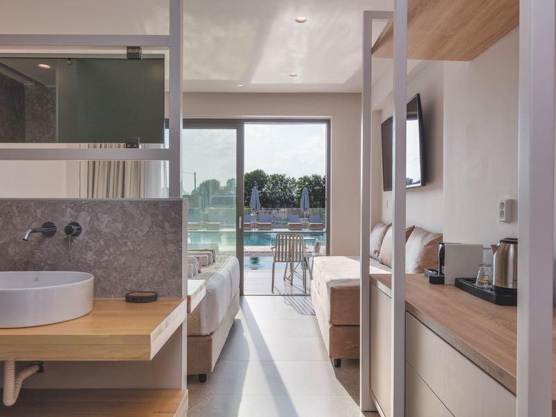 Nowoczesny pokój hotelowy z łazienką, łóżkiem i balkonem z widokiem na hotel