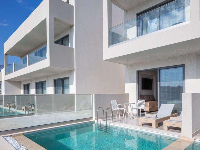 Nowoczesny balkon hotelowy ze szklanym balustradą, basenem i miejscem do siedzenia w słoneczną pogodę.