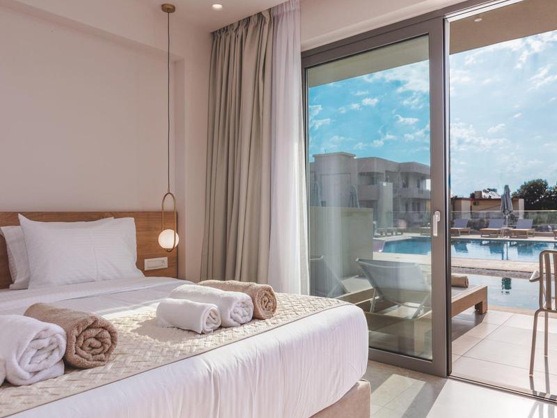 Jasny pokój z widokiem na basen przez duże szklane okna i balkon