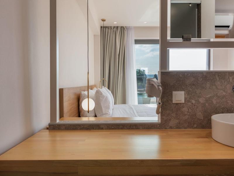 Nowoczesna przestrzeń pokoju hotelowego z drewnianą umywalką i widokiem na sypialnię