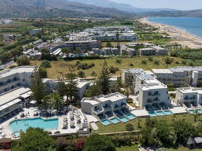 Grande complesso alberghiero con più edifici, piscina e accesso diretto alla spiaggia in un paesaggio costiero.