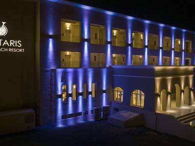 Beleuchtetes Hotelgebäude mit blauem Licht, Balustraden und markantem Eingang bei Nacht.