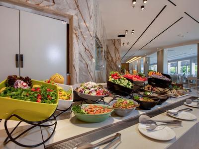 Buffet con varie insalate fresche e antipasti in un ristorante moderno.