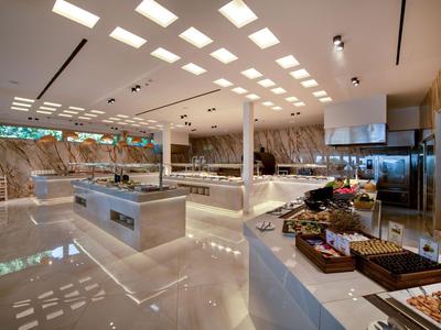 Cucina d'hotel moderna con piani di lavoro lucidi e attrezzature ampie.
