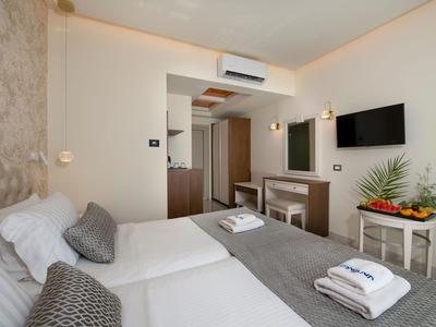 Camera d'hotel arredata modernamente con due letti, TV e decorazioni.